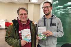 Zwei Autoren der Glücksorte-Reihe haben ihre Bücher getauscht: links Andreas Stahl (Autor von Glücksorte im Westerwald) und rechts René Schwarz (Glücksorte in Helsinki