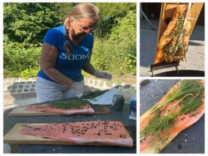 Die Lachsseiten werden gesalzen, gepfeffert und mit Dill belegt. Anschließend werden sie auf Brettern befestigt und an das Feuer gestellt